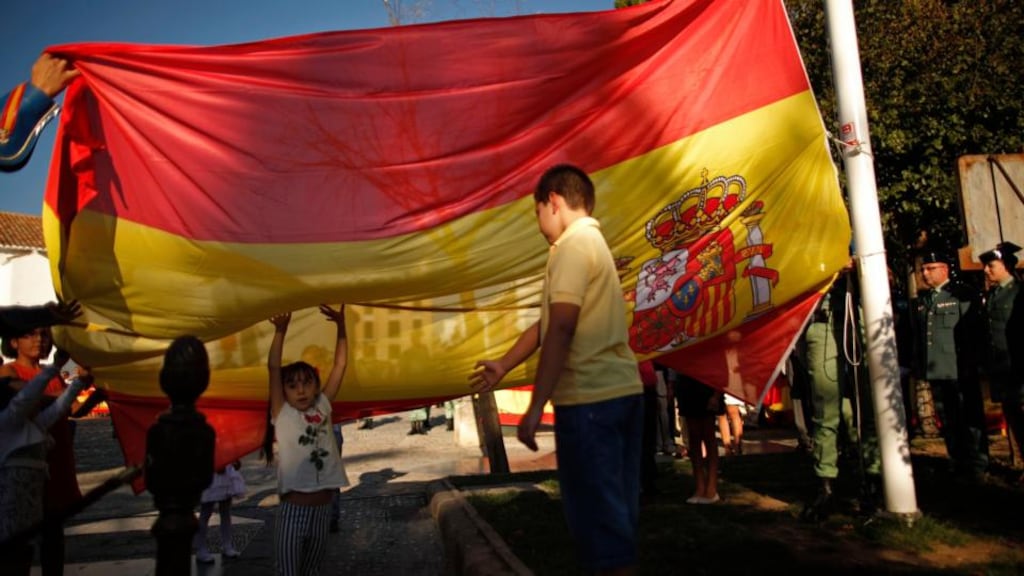 Children hoist the Spanish flag with Spanish legionnaires during a ceremony on the eve of the Spain’s National Day in Ronda, near Malaga. Spain is on a path of slow but stable economic recovery. Photograph: Jon Nazca / Reuters