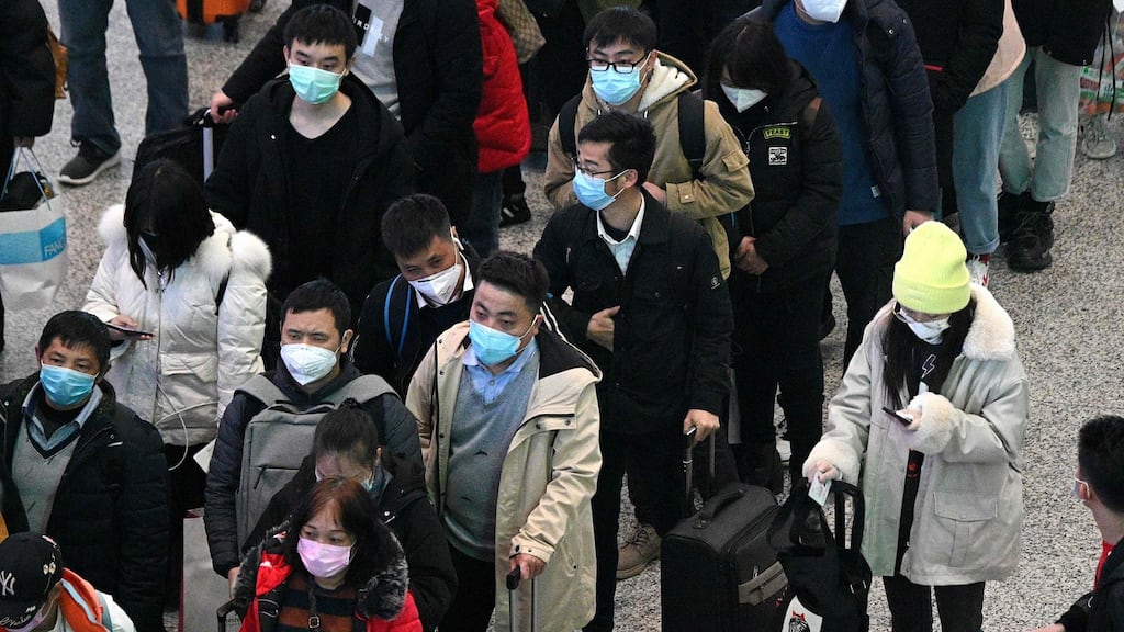 Passengers wearing protective face masks arrive at the Hongqiao railway station in Shanghai. Photograph: Noel Celis/AFP via Getty Images