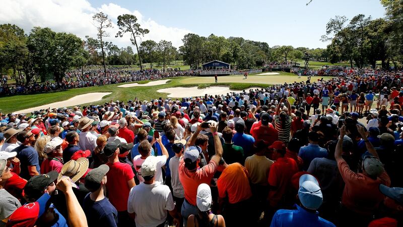 Huge crowds watch Woods putt out on the fourth green. Photo: Michael Reaves/Getty Images