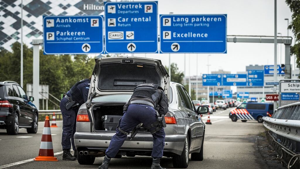 Dutch police officers search a car boot on the way to Schipol Airport in Amsterdam. Photograph: Remko De Waal/AFP/Getty Images