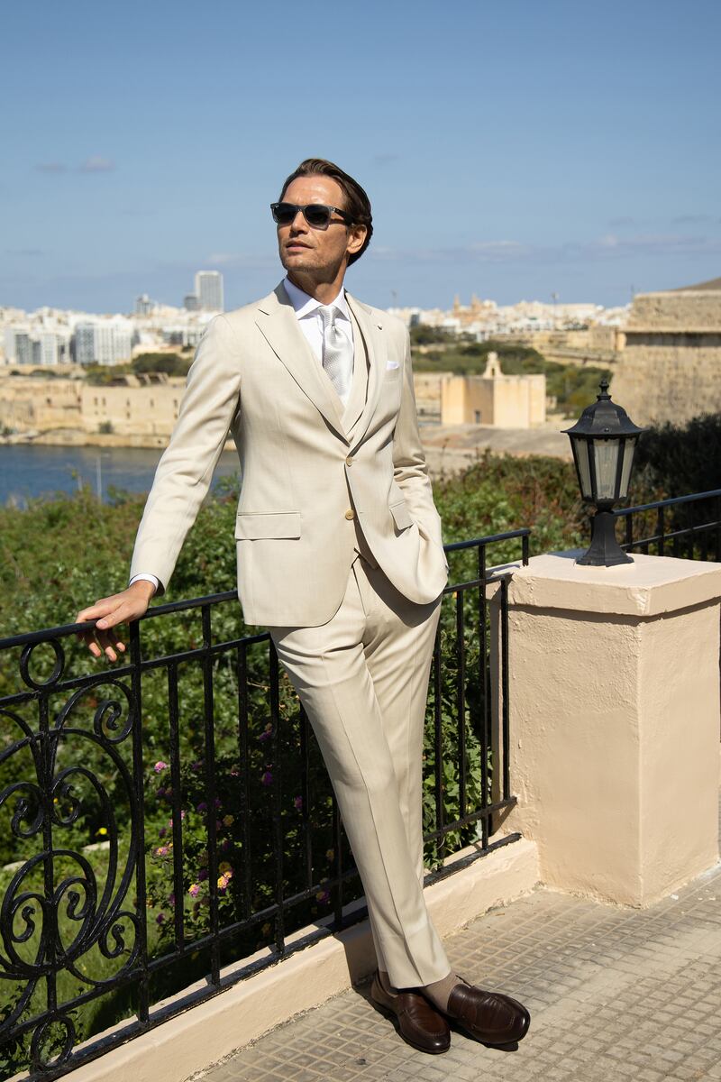 Three-piece beige herringbone suit (€1,699), slim-fit pinpoint white shirt (€159), Brown penny loafers (€520), from Louis Copeland