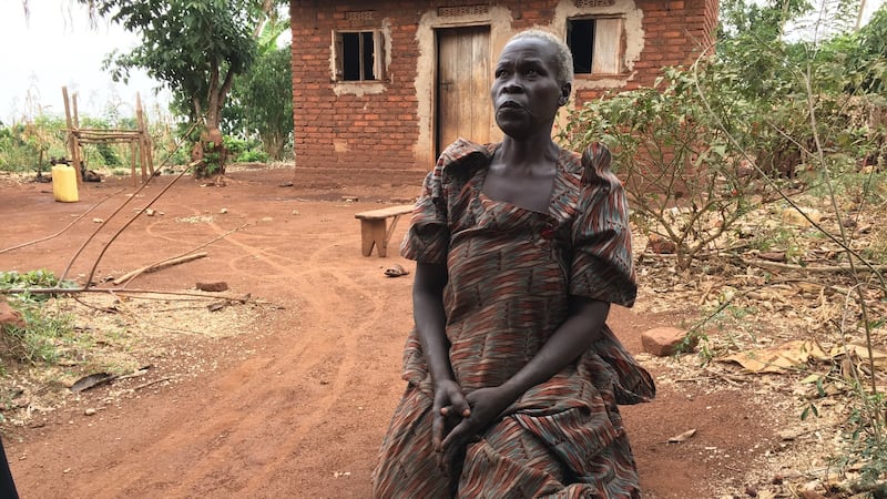 Bitu Nangobi kneels outside her home in the village of Bulangira Bukose, near the Isimba dam. Photograph: Dan Griffin
