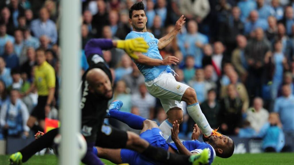 Sergio Aguero of Manchester City shoots past Sylvain Distin  and Tim Howard  of Everton to score his team’s second goal during the  Premier League match  at Etihad Stadium. Photograph: Shaun Botterill/Getty Images