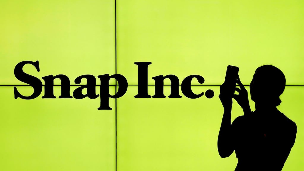 A woman stands in front of the logo of Snap Inc on the floor of the New York Stock Exchange. Photograph: Lucas Jackson/Reuters.