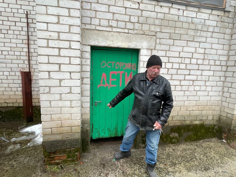 Ivan Polgui outside the door leading to the basement of a school where hundreds were imprisoned by Russian troops. The words on the door mean 'be careful - children'. Photograph: Daniel McLaughlin