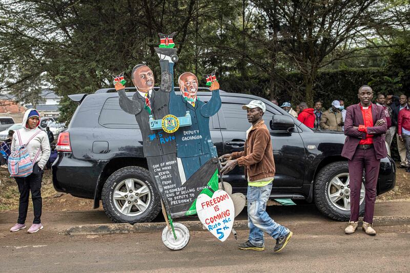 A UDA supporter pushes a chariot portraying Kenyan president-elect William Ruto and his running mate, Rigathi Gachagua, during the inaugural meeting of elected officials outside Mr Ruto's residence in Karen, near Nairobi. Photograph: Patrick Meinhardt/AFP