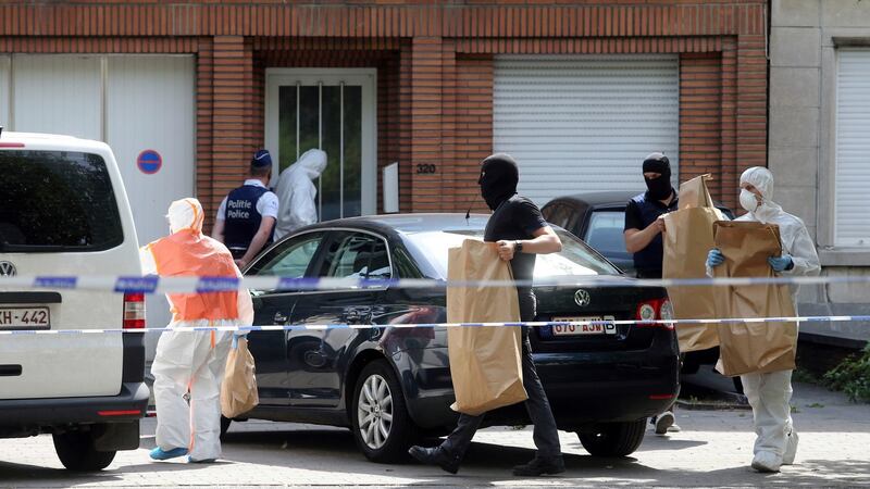 Police and forensic officers remove items during a house search in the Molenbeek district of Brussels. Photograph: AP Photo/Francois Walschaerts