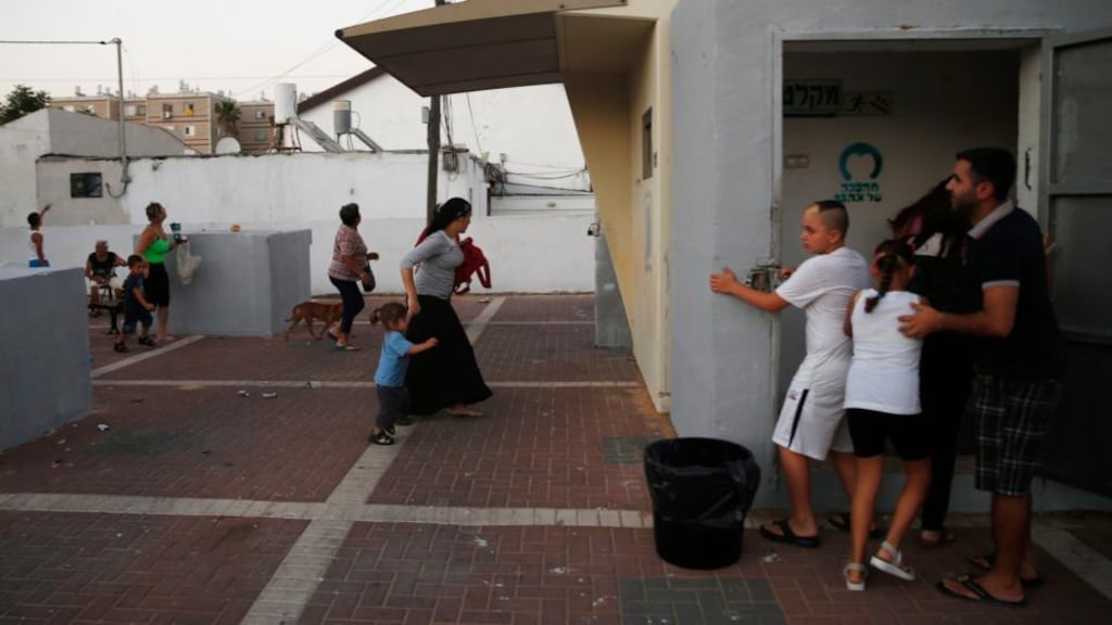 Israelis run towards a bomb shelter as a siren sounds warning of incoming rockets in the southern city of Ashkelon yesterday. Photograph: Reuters/Baz Ratner