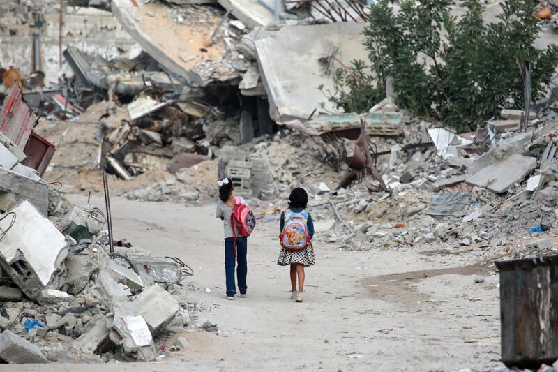 Girls walk past destroyed buildings in Khan Yunis in the southern Gaza Strip on October 17th. Photograph: Bashar Taleb/AFP via Getty