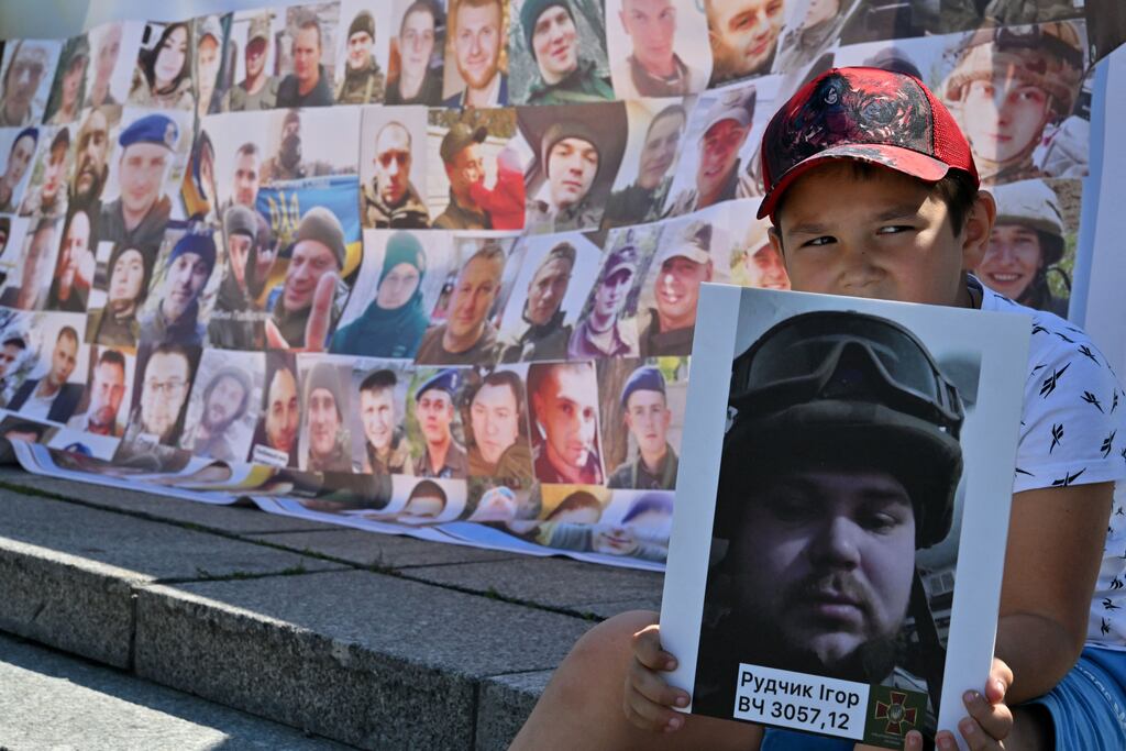 A child holds a portrait of his brother during a rally of relatives of missing and imprisoned Ukrainian servicemen demanding their search and liberation at Independence Square in Kyiv on August 4th, 2023. Photograph: Sergei Supinsky/AFP via Getty Images