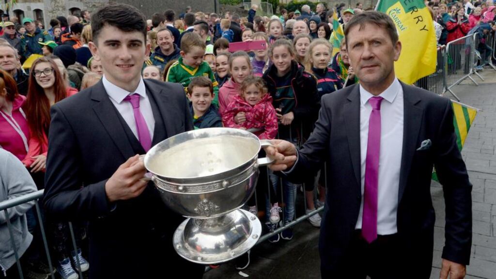Kerry minor team captain Mark O’Connor and manager Jack O’Connor hold up their All-Ireland trophy at the traditional first stop in Rathmore as both the senior and minor teams arrived back home to Kerry by train. Photograph: Don MacMonagle