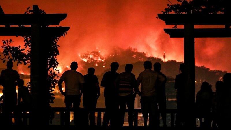 People watch as a forest fire burns on a hill in Monchique, Portugal, on Sunday. Photograph: Filipe Farinha/EPA