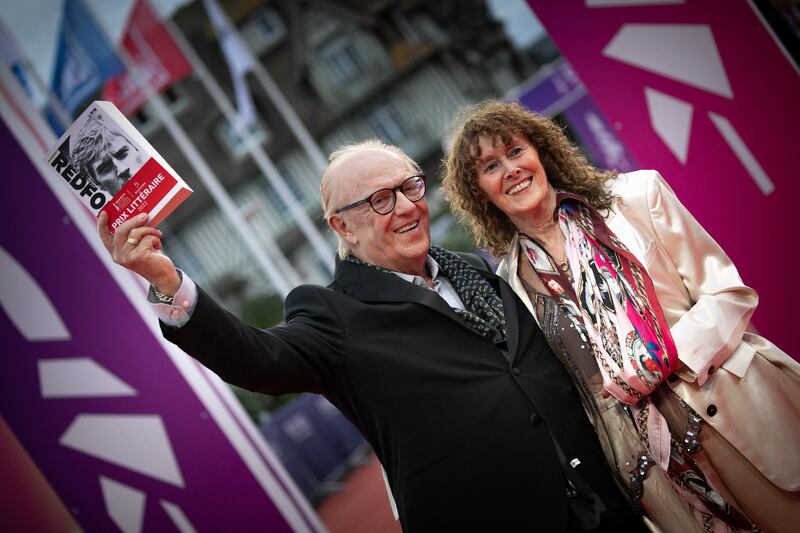 Irish writer Michael Feeney Callan holds his prize-winning book Robert Redford as he poses with wife Ree Ward Callan on the red carpet of the 48th Deauville American Film Festival in Normandy, 2022. Photograph: Lou Benoist/ AFP via Getty Images