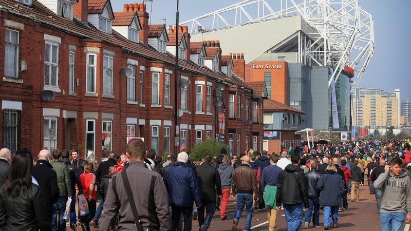 Mancnester United Fans walk along Matt Busby Way towards Old Trafford. Photo: Simon Stacpoole/Mark Leech Sports Photography/Getty Images