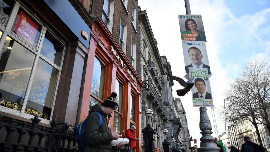 A pedestrian walks past election posters in Dublin ahead of the general election. File photograph: Ben Stansall/AFP via Getty Images