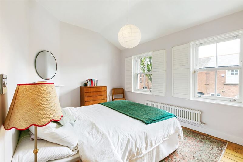 The main bedroom spans the front of the first floor, flooded with light from the two sash windows.