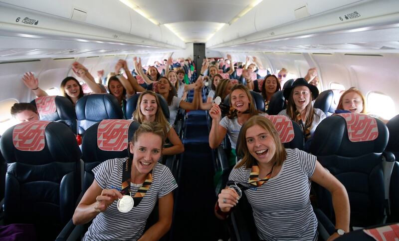 TOP-FLIGHT: The Irish hockey team prepares to return home on a Cityjet flight from London after their unprecedented silver medal finish at the Hockey World Cup in London. Nicci Daly (left) and Katie Mullan show off their medals in front. Photograph: Nick Bradshaw