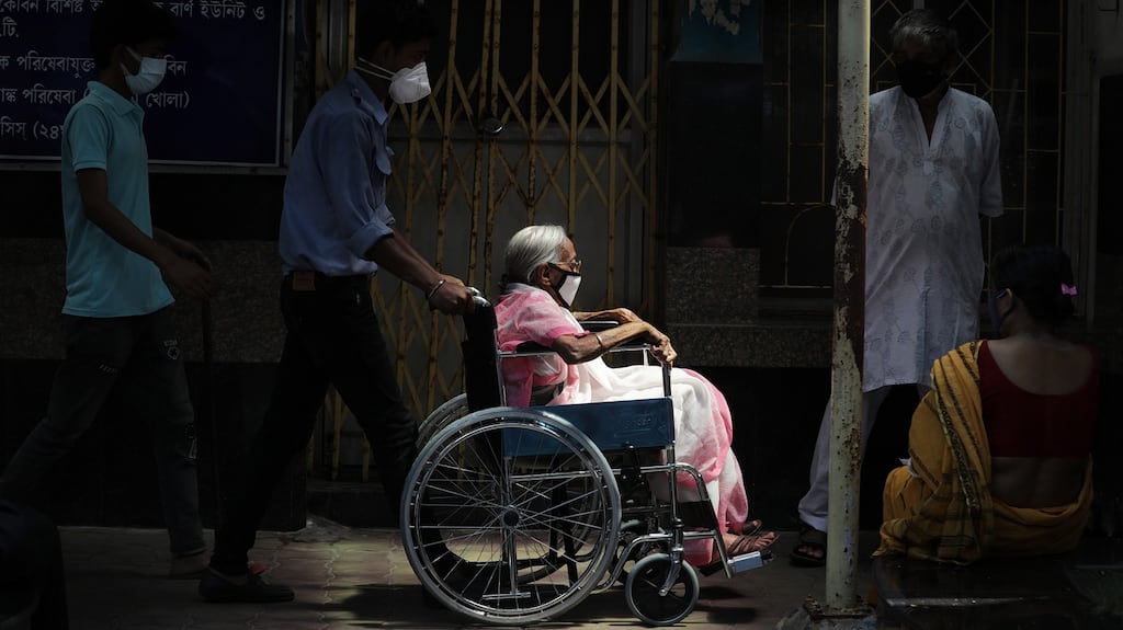 Relatives push an elderly woman in a wheelchair as she arrives for a Covid-19 vaccination at a government hospital in Kolkata, India. Photograph: Piyal Adhikary/EPA