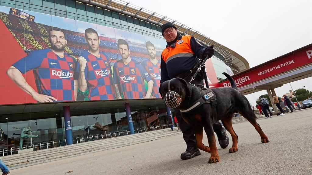 A private security guard and his dog in front of the Nou Camp stadium in Barcelona. Photo: Alejandro Garcia/EPA