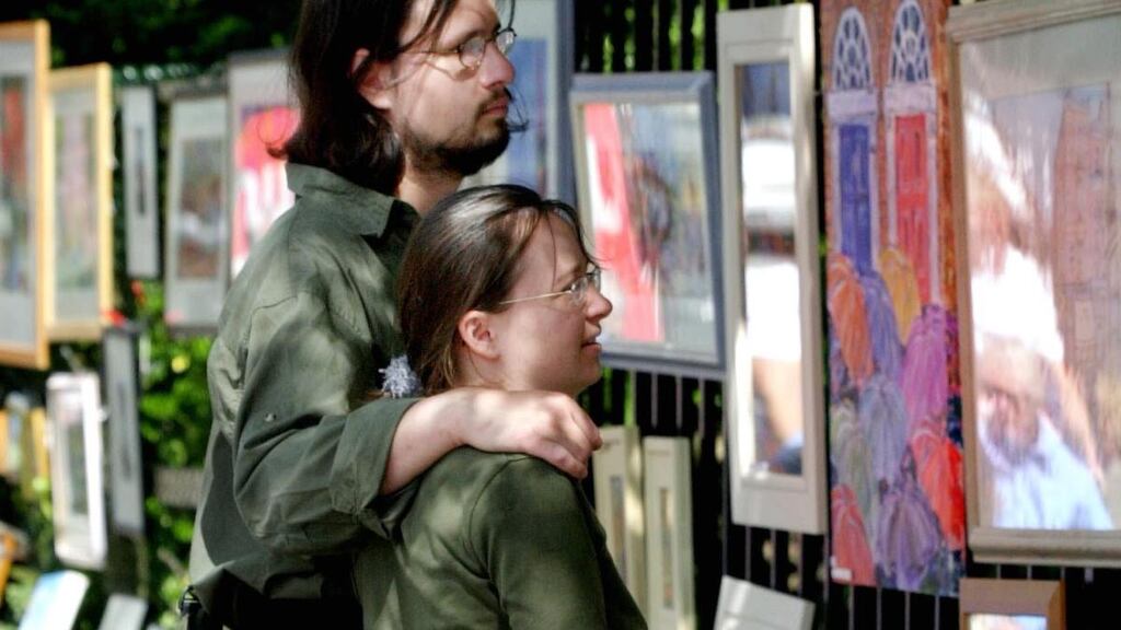 A couple enjoy the work on show in the Merrion Square Open Art Exhibition. File photograph: Bryan O’Brien