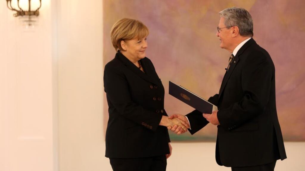German president Joachim Gauck (R) gives chancellor Angela Merkel her new appointment papers during a ceremony in Berlin today. Photograph:  Adam Berry/Getty Images.