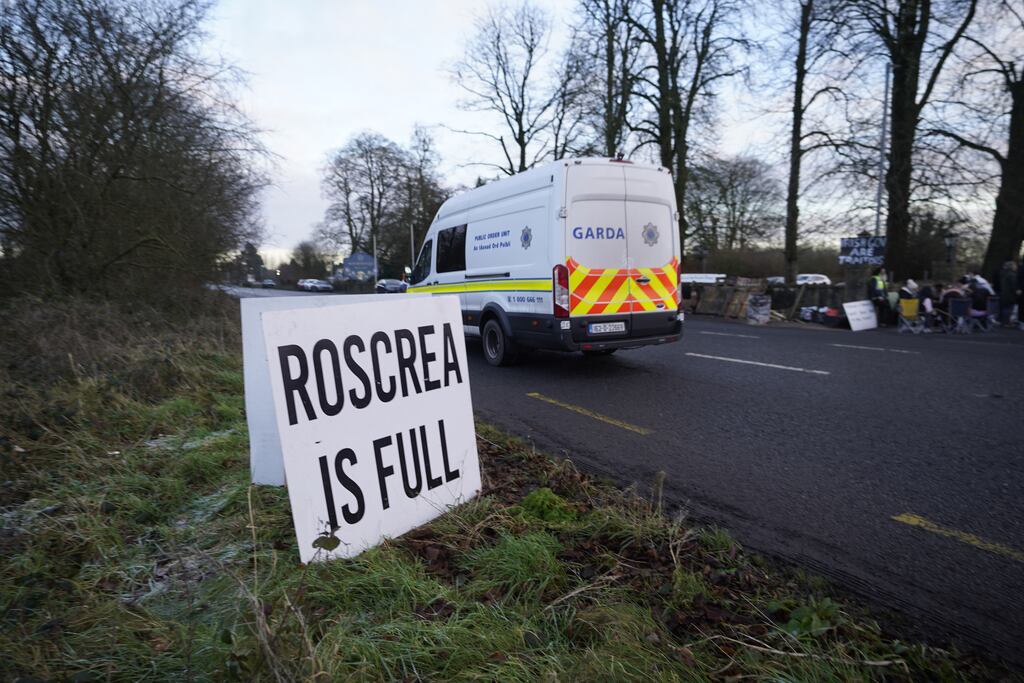 A Garda van passes protesters at the Racket Hall hotel in Roscrea, Co Tipperary demonstrating over plans to house asylum seeker family applicants in the hotel. Photograph: Niall Carson/PA Wire