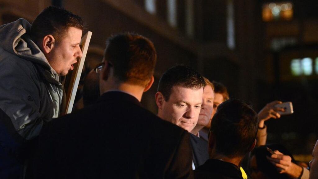 A protester holds up a sign as Minister for Environment Alan Kelly talks to reporters at the end of the forum on homelessness which took place at the Custom House on Thursday. Photograph: The Irish Times/Dave Meehan