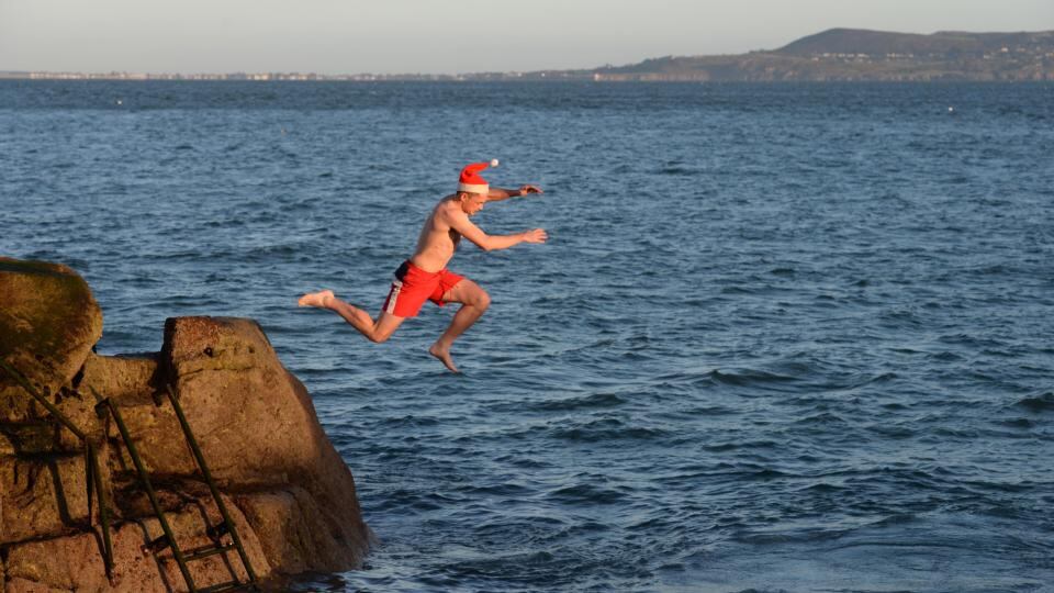 A hardy annual:  A man in a Santa hat takes the plunge at the 2014  Christmas Day Swim at the Forty Foot. Photograph: Dara Mac Dónaill/The Irish Times