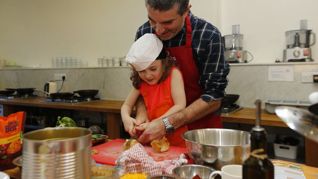 Damian Cullen helps his five-year-old daughter – or maybe more accurately Eve helps her father – to make ‘Bangin’ Burritos with Steak and Mexican Rice’ at Dublin’s Cooks Academy as part of ‘Cook Along with Ben’s Beginners’, which promotes children and parents cooking together. Photograph: Robbie Reynolds