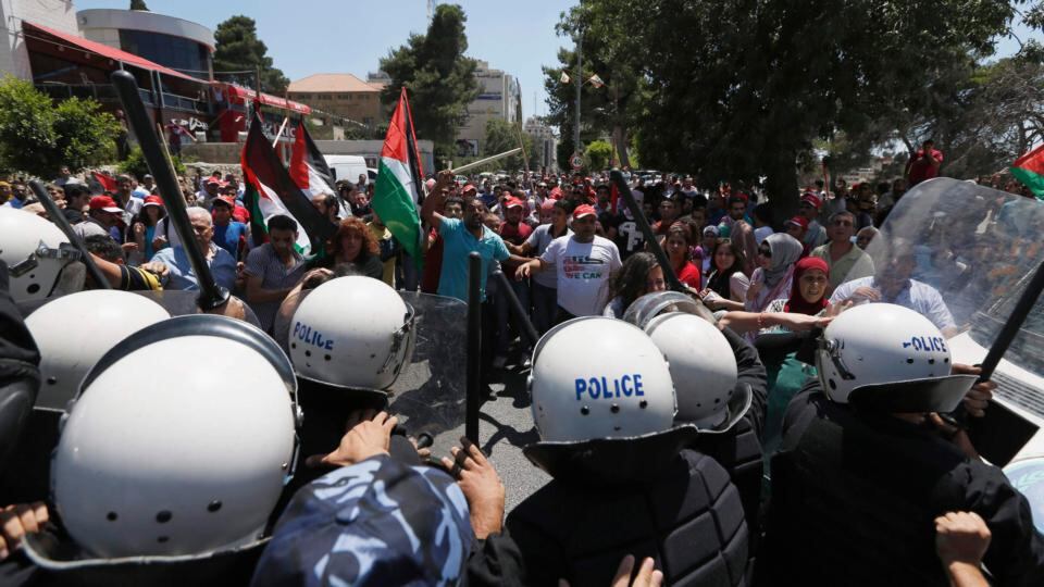 Palestinian police officers stand in front of protesters during a demonstration against the renewal of stalled peace talks with Israel, in the West Bank city of Ramallah today. Photograph: Mohamad Torokman/Reuters
