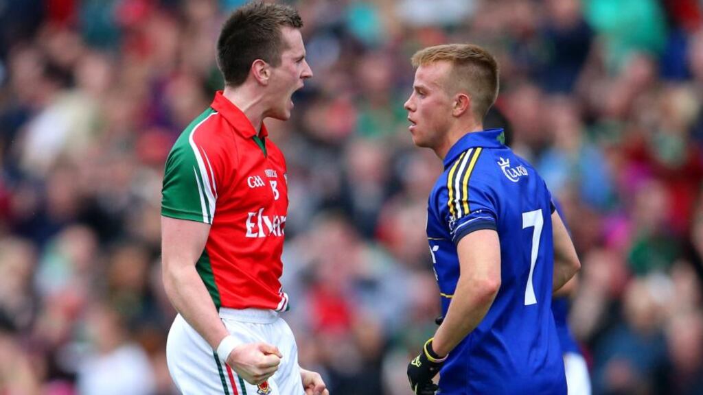 Mayo’s Cillian O’Connor celebrates after scoring a point as Fionn Fitzgerald of Kerry looks on. Photograph: Cathal Noonan/Inpho