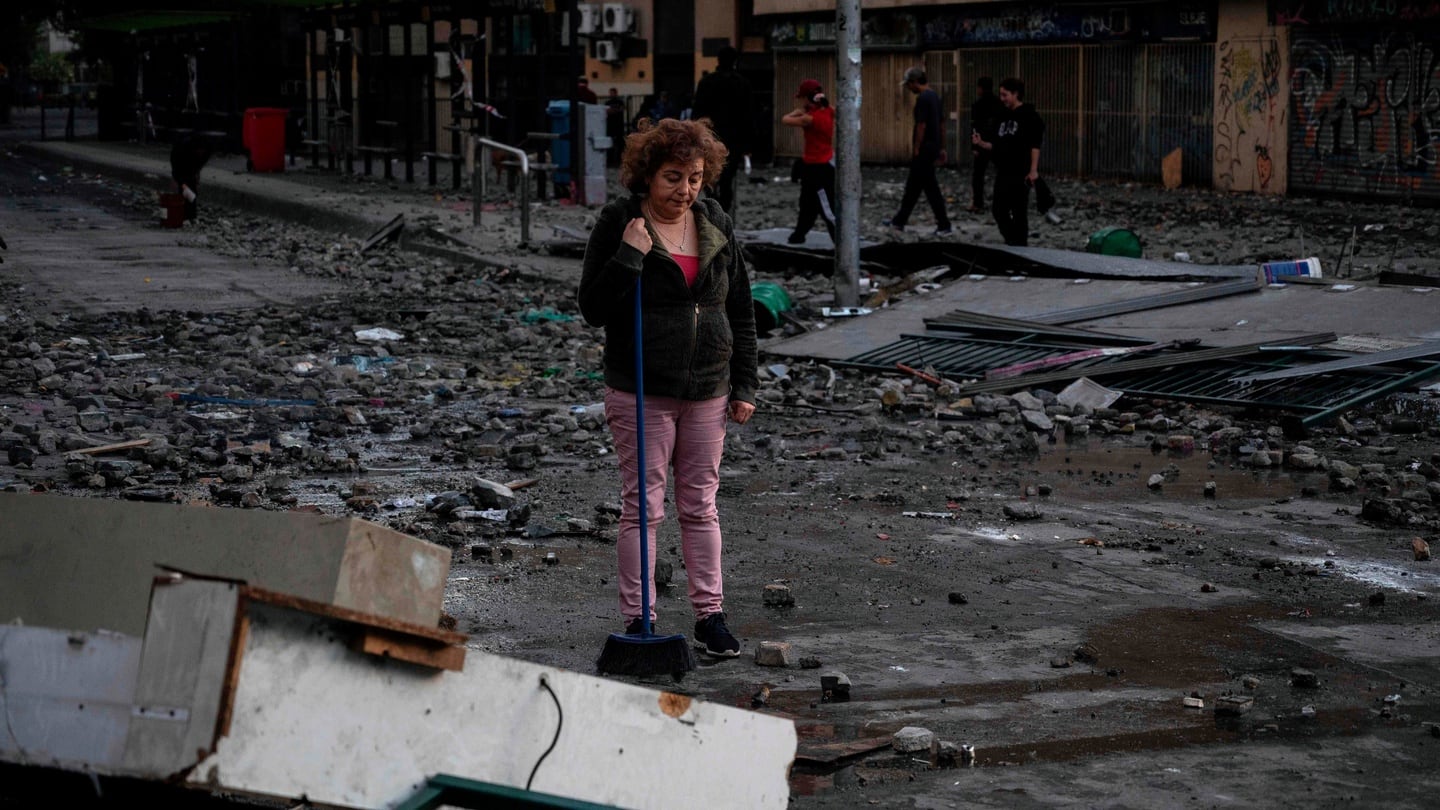 A  woman looks at a damaged street after clashes in Santiago on Monday. Photograph:  Pedro Ugarte/ AFP/ Getty