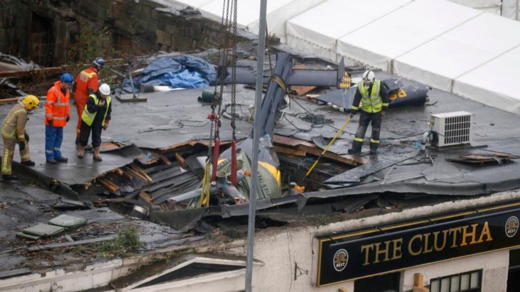 Rescue workers prepare to lift the wreckage of a police helicopter that crashed into a pub in central Glasgow. Photograph: Reuters