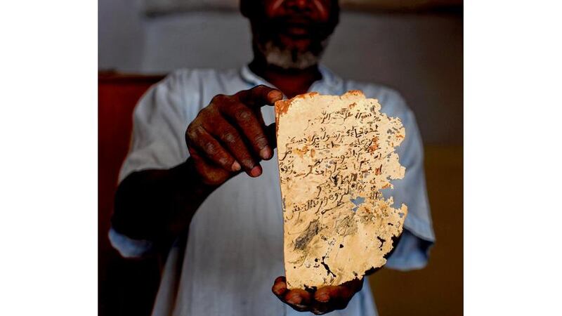 Konate Alpha holds an ancient manuscript he hid from extremists in Timbuktu;. Photograph: Tyler Hicks /New York Times