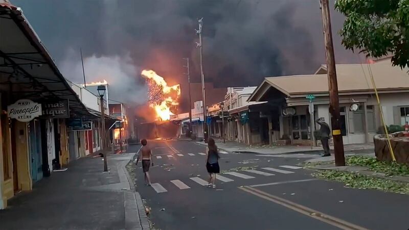 People watch as smoke and flames fill the air from raging wildfires on Front Street in Lahaina, Maui. Photograph: Alan Dickar via AP
