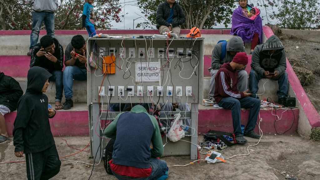 Migrants charge phones at a temporary camp in Matamoros, Mexico, near the US border, earlier this year. File photograph: Meghan Dhaliwal/New York Times