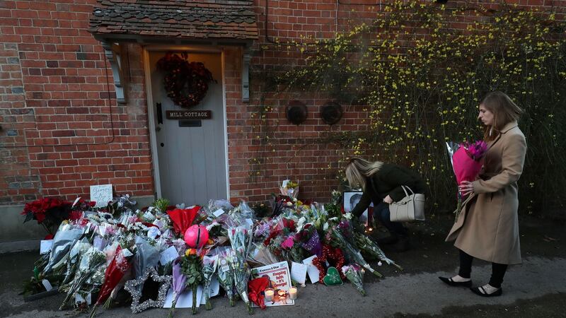 A woman lays flowers outside the Goring home of late pop star George Michael in Oxfordshire after he died at age 53 on Christmas Day 2016. Photograph: Andrew Matthews/PA Wire