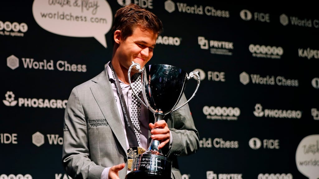 World chess champion Norway’s Magnus Carlsen poses with the FIDE world chess championship trophy after beating challenger, US player Fabiano Caruana. Photograph: Tolga Akmen/ AFP/Getty Images