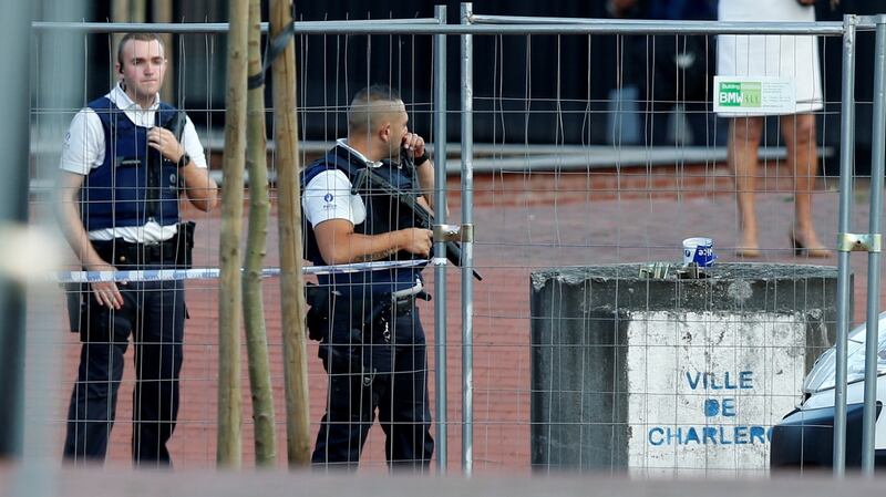 Belgian police officers stand guard outside the main police station after a machete-wielding man injured two female police officers before being shot. Photograph: Francois Lenoir/Reuters