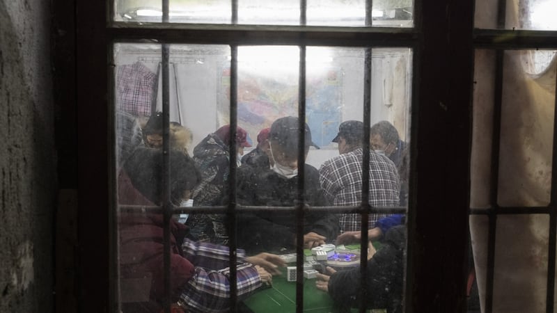 Masked patrons play mah-jongg at a parlor in an alleyway in Wuhan on January 6th. Photograph: Gilles Sabrie/The New York Times