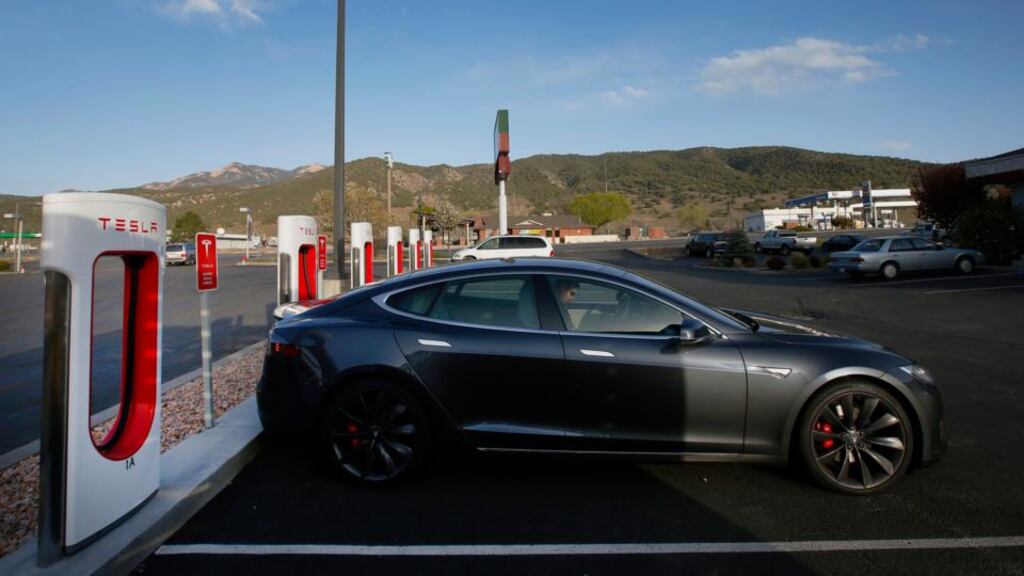A Tesla Model S P85D vehicle sits plugged in at a charging station in Nephi, Utah