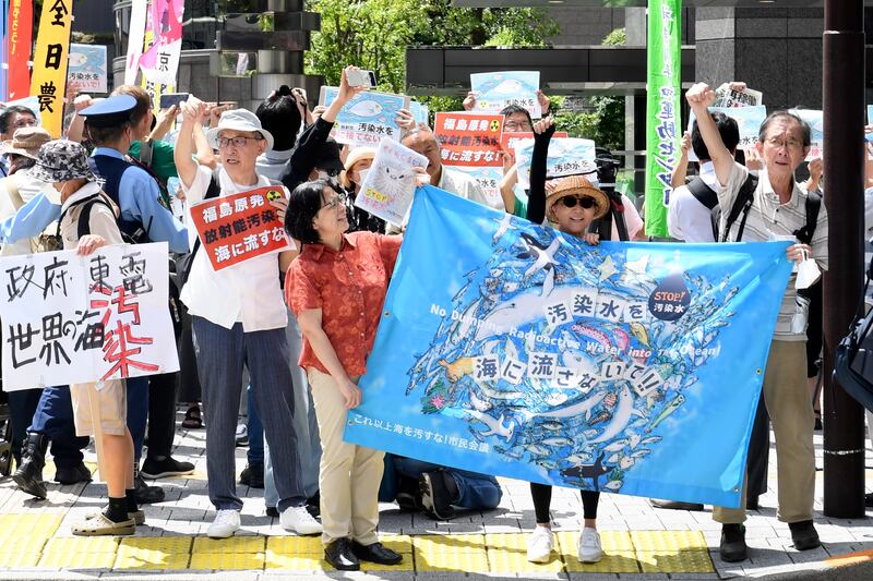 A protester holds a sign during a rally against the treated radioactive water release from the damaged Fukushima nuclear power plant in front of TEPCO headquarters in Tokyo. Photograph: Norihiro Haruta, AP