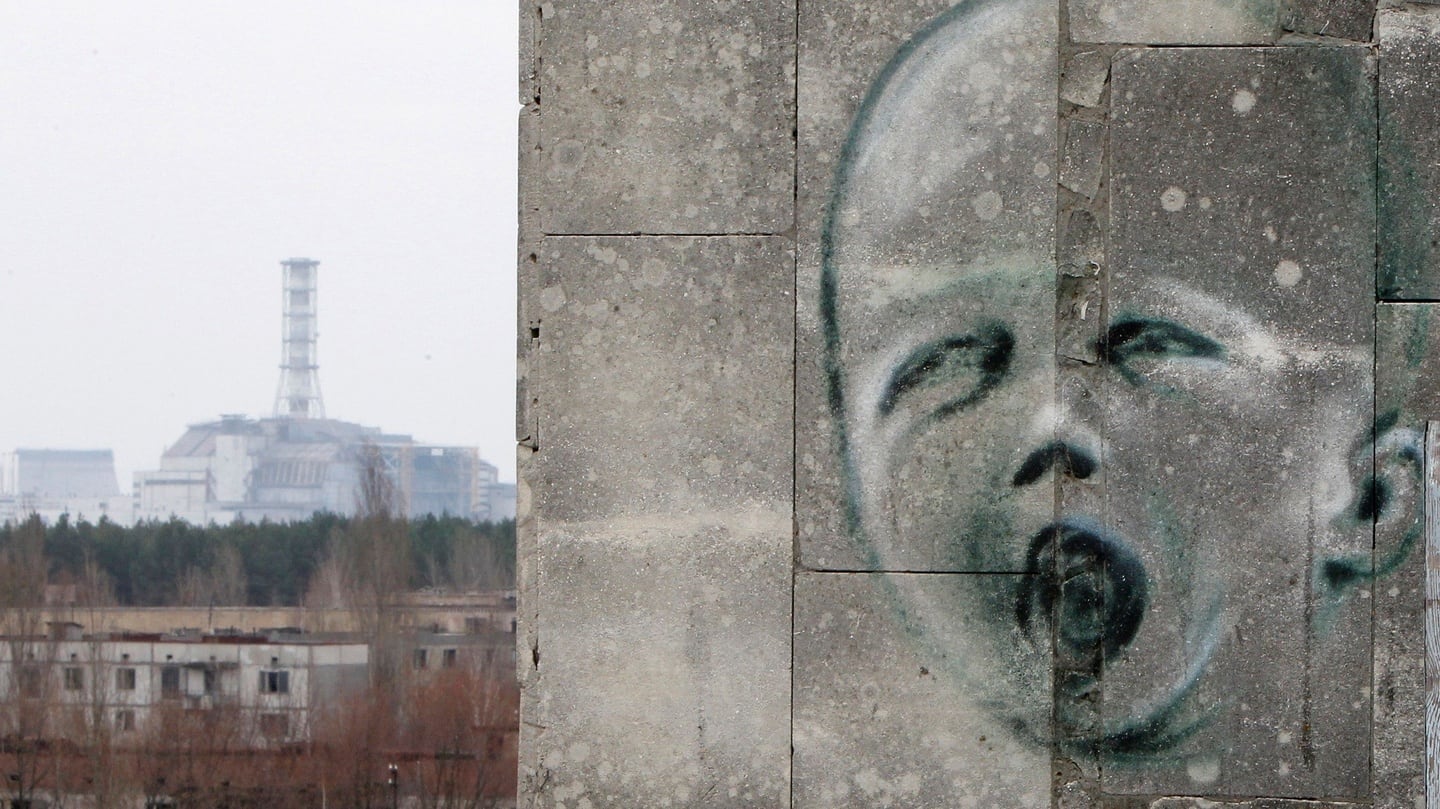 The sarcophagus covering the damaged fourth reactor at the Chernobyl nuclear power plant seen behind a building in the abandoned city of Prypiat. Photograph: Gleb Garanich/Reuters