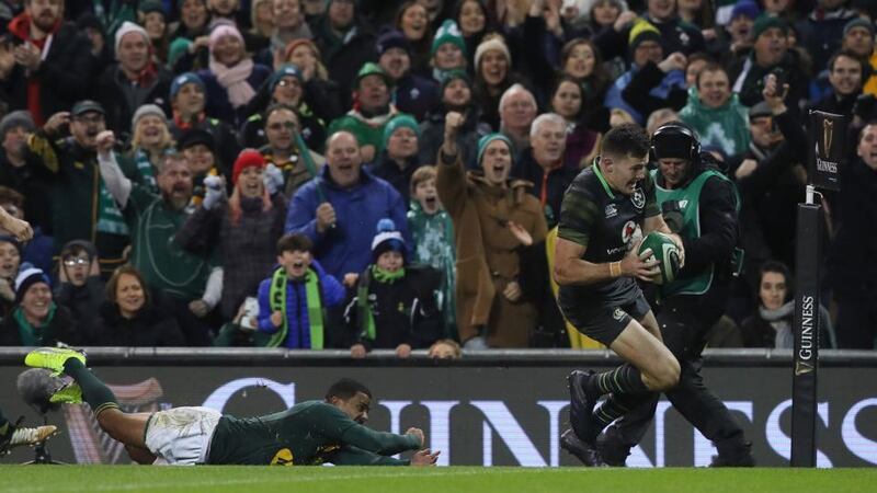 Ireland’s Jacob Stockdale goes past South Africa’s Rudy Paige. Photograph: Brian Lawless/PA Wire.