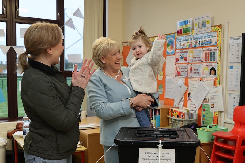 Fine Gael candidate Heather Humphreys casts her vote in the presidential election with the help of her one-year-old granddaughter Charlotte and daughter Eva (left) at Killeevan Central National School in Newbliss, Co Monaghan, on Friday. Photograph: Liam McBurney/PA Wire