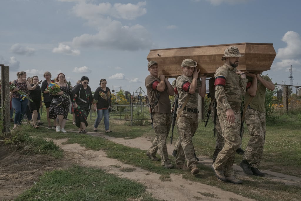 Ukrainian soldiers of the Azov Battalion bury a comrade in Baryshivka, a small village in north-central Ukraine. Photograph: Mauricio Lima/The New York Times