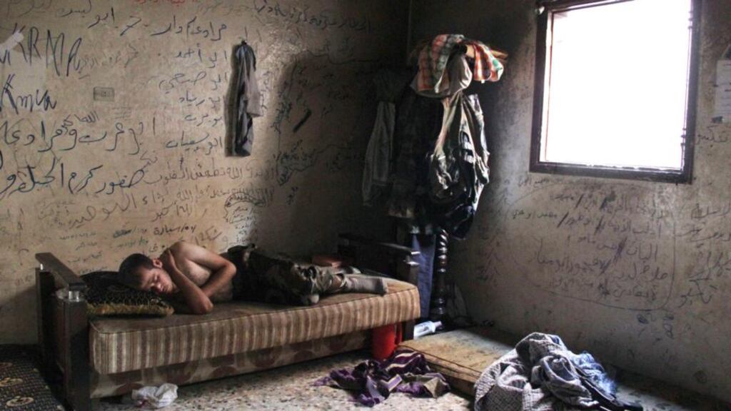 A Free Syrian Army fighter rests inside a house in Aleppo’s Karm al-Jabal district. Photograph: Loubna Mrie /Reuters.