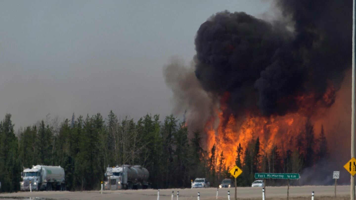 Flames are seen along highway 63 about 14kms south of Fort McMurray, Alberta, on Friday. Officials said shifting winds were giving the embattled northern Alberta city a break, but they added the fire remained out of control and was likely to burn for weeks. Photograph: PA