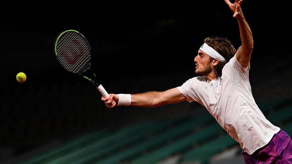 Greece’s Stefanos Tsitsipas returns the ball to John Isner of the US during their third-round match at the French Open at Roland Garros. Photograph: Christophe Archambault/AFP via Getty Images