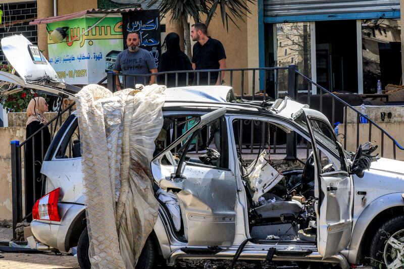 People inspect the wreckage of a vehicle hit in an Israeli drone strike in Bint Jbeil in southern Lebanon. Photograph: Mahmoud Zayyat/AFP/via Getty Images